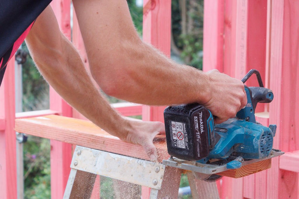 NFL Construction builder cutting timber on site